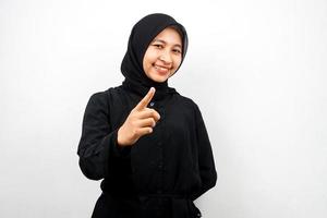 Beautiful young asian muslim woman smiling confident and cheerful, with hands pointing at camera, pointing at audience, pointing to customer, isolated on white background