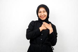 Hermosa y alegre joven mujer musulmana asiática, con las manos sosteniendo el pecho, aislado sobre fondo blanco. foto