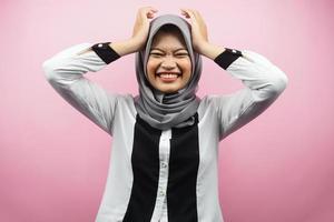 Hermosa joven musulmana asiática conmocionada, mareada, estresada, infeliz, con muchos problemas, quiere solución, con las manos sosteniendo la cabeza aislada sobre fondo rosa
