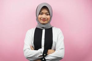 Hermosa joven mujer musulmana asiática sonriendo con confianza con los brazos extendidos frente a la cámara aislada sobre fondo de color rosa foto