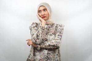 Hermosa mujer musulmana asiática joven pensando, buscando ideas, buscando soluciones a los problemas, con las manos sosteniendo las mejillas, aislado sobre fondo blanco. foto