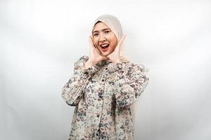 Hermosa joven mujer musulmana asiática conmocionada, sorprendida, expresión guau, con las manos sosteniendo la mejilla, aislado sobre fondo blanco. foto