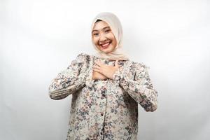 Beautiful young asian muslim woman smiling surprised and cheerful, with  hands holding chest, excited, not expecting, looking at camera isolated on white background photo