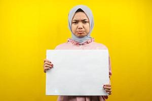 Pretty young muslim woman sad holding blank empty banner, placard, white board, blank sign board, white advertisement board, presenting something in copy space, promotion photo