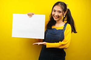 Pretty and cute young woman cheerful holding blank empty banner, placard, white board, blank sign board, white advertisement board, presenting something in copy space, promotion photo