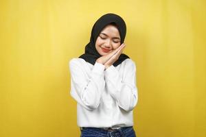 Hermosa joven musulmana asiática durmiendo pacíficamente, sintiéndose cómoda, sintiéndose feliz, aislada sobre fondo amarillo