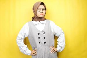 Beautiful young asian muslim woman pouting, angry, feeling annoyed, dissatisfied, uncomfortable, feeling bullied, lied to, looking at camera isolated on yellow background photo