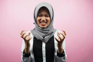 Hermosa joven musulmana asiática conmocionada, mareada, estresada, infeliz, con muchos problemas, quiere una solución, con las manos arriba aisladas sobre fondo rosa foto