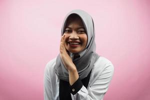 Beautiful young asian muslim woman smiling confidently and excitedly close to camera, whispering, telling secrets, speaking quietly, silent, isolated on pink background