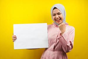 Pretty young muslim woman cheerful holding blank empty banner, placard, white board, blank sign board, white advertisement board, presenting something in copy space, promotion photo