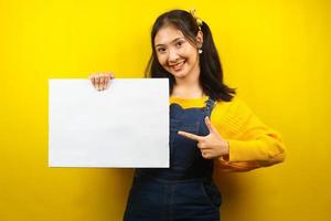 Pretty and cute young woman cheerful holding blank empty banner, placard, white board, blank sign board, white advertisement board, presenting something in copy space, promotion photo