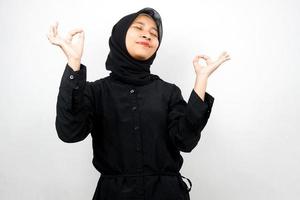 Hermosa joven musulmana con las manos meditando signo, sonriendo cómodo y feliz, aislado sobre fondo blanco. foto