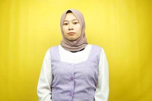 Hermosa joven musulmana asiática haciendo pucheros mirando a la cámara aislada sobre fondo amarillo foto