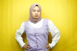 Beautiful young asian muslim woman pouting, angry, feeling annoyed, dissatisfied, uncomfortable, feeling bullied, lied to, looking at camera isolated on yellow background photo