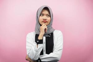 Hermosa joven musulmana asiática pensando, hay un problema, se siente extraño, algo anda mal, buscando una solución, aislado sobre fondo rosa
