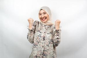 Hermosa joven musulmana asiática confiada y sonriente, con puño cerrado, puñetazos, signo de espíritu, lucha, signo de victoria, aislado sobre fondo blanco. foto
