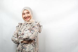 Beautiful young asian muslim woman confident and cheerful looking empty space presenting something, isolated on white background photo