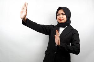 Hermosa mujer de negocios musulmana joven asiática con la mano rechazando algo, la mano deteniendo algo, disgustando algo en el espacio vacío, aislado sobre fondo blanco.
