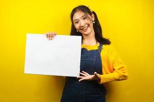 Pretty and cute young woman cheerful holding blank empty banner, placard, white board, blank sign board, white advertisement board, presenting something in copy space, promotion photo