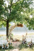 wedding ceremony area with dried flowers in a meadow in a forest photo