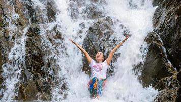 Girl traveling waterfall on holiday. The girl who is enjoying playing the waterfall happily. travel nature, Travel relax, travel Thailand. Huai Toh waterfall at Krabi.