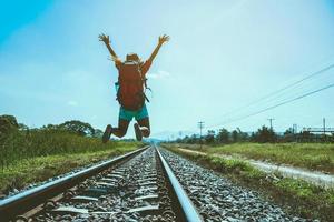 Asian women travel countryside. Travel relax. bag backpack travel. Walk on the railroad. Thailand