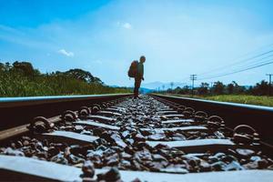 Asian men travel countryside. Travel relax. bag backpack travel. Walk on the railroad. Thailand