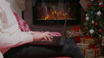 homem mãos digitando no laptop trabalhando em casa, plano de fundo de Natal. video