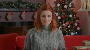 mujer mirando a la cámara con caja de regalo de Navidad sobre fondo de luces de Navidad. video