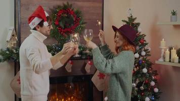 pareja bailando con fuego de bengala riendo y celebrando la Navidad juntos. video
