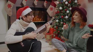 pareja cantando marido y mujer divirtiéndose en las vacaciones de Navidad.