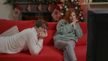 casal assistindo tv no fundo do Natal. video