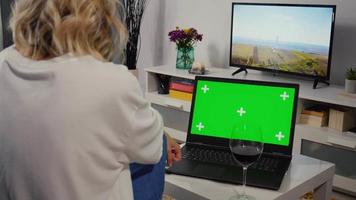 Woman Watching Laptop Green Screen while Drinking a Glass of Wine. video