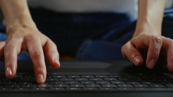 manos femeninas escribiendo en el teclado de la computadora portátil. video