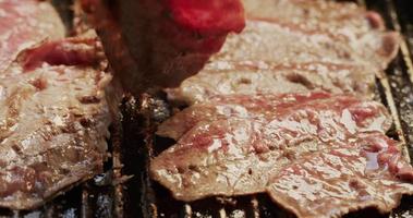 close-up detail - chef-kok draait gegrilde biefstuk in koekenpan. video