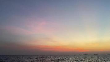 cielo nublado con puesta de sol en el mar, la luz del sol brilla en el horizonte. video