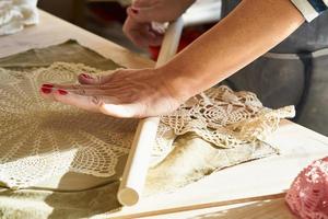 Mujer haciendo patrón en placa de cerámica, manos de cerca, se centran en las palmas de las manos con arcilla foto