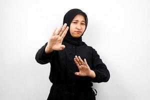 Hermosa joven musulmana asiática con la mano de la señal de pare, rechazar la mano de la señal, mano de la señal de prohibición, no acercarse a la mano, mantenerse alejado de la mano del signo, no mover la mano del signo, aislado sobre fondo blanco. foto