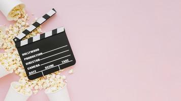 top view cinema clapperboard with popcorn photo