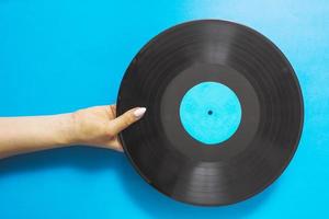 overhead view female hands holding vinyl record blue background photo