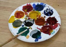 pallette with brush on wooden table photo