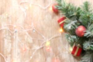 blurred christmas tree background with decorations and light on wooden board photo