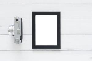 Creative flat lay photo of workspace desk. Office desk wooden table with old camera and poster mockup template. Top view with copy space. Top view of old camera over wooden table. Retro vintage filter