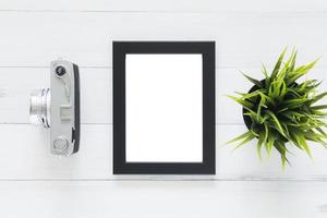 Creative flat lay photo of workspace desk. Office desk wooden table with old camera and poster mockup template. Top view with copy space. Top view of old camera over wooden table. Retro vintage filter