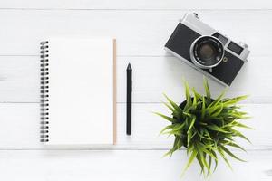 espacio de trabajo mínimo: foto creativa plana del escritorio del espacio de trabajo. Fondo de mesa de madera de escritorio de oficina blanco con maquetas de cuadernos y cámara retro. vista superior con espacio de copia, fotografía plana