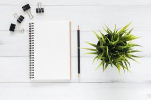 espacio de trabajo mínimo: foto creativa plana del escritorio del espacio de trabajo. Fondo de mesa de madera de escritorio de oficina blanco con maquetas de cuadernos y lápiz y planta. vista superior con espacio de copia, fotografía plana