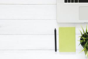 Minimal work space - Creative flat lay photo of workspace desk. Top view office desk with laptop, mock up notebooks and plant on white wooden background. Top view with copy space, flat lay photography