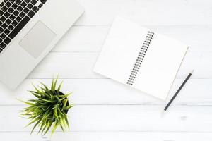 Minimal work space - Creative flat lay photo of workspace desk. Top view office desk with laptop, mock up notebooks and plant on white wooden background. Top view with copy space, flat lay photography