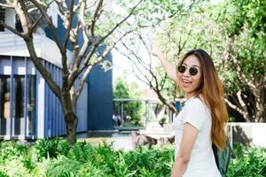 A young Asian woman enjoying in the garden for her city lifestyle on weekend morning. Young woman with her weekend city lifestyle in garden. Outdoor activity and city lifestyle concept.
