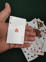 The man's hand throws a deck of cards onto the game table.